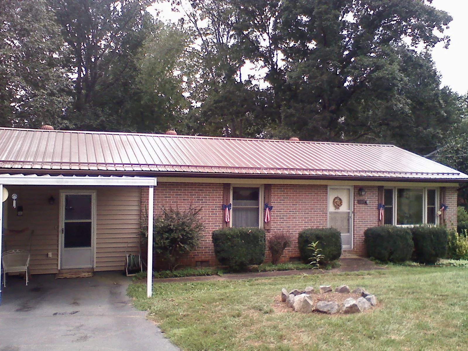 Bronze metal roof and carport on a brick ranch home — Roof Repair work by our crew in Pamplin